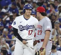 ７回、四球で出塁し、一塁手スチュワート（右）と笑顔で言葉を交わす大谷（共同）
