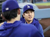 　レッズ戦の１回、ベンチで佐々木朗（左）と話すドジャース・大谷＝ロサンゼルス（共同）