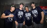 　ナ・リーグ西地区５連覇を達成し、シャンパンファイトで写真に納まるドジャースの（左から）山本、スクバル、ロバーツ監督、スネル＝シンシナティ（共同）
