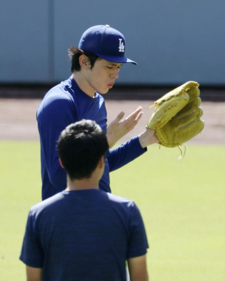 　キャッチボール中、指先を気にするドジャース・佐々木朗＝ロサンゼルス（共同）