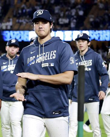 　チームメートを出迎え、ベンチに戻るドジャース・大谷。右は佐々木朗＝ロサンゼルス（共同）