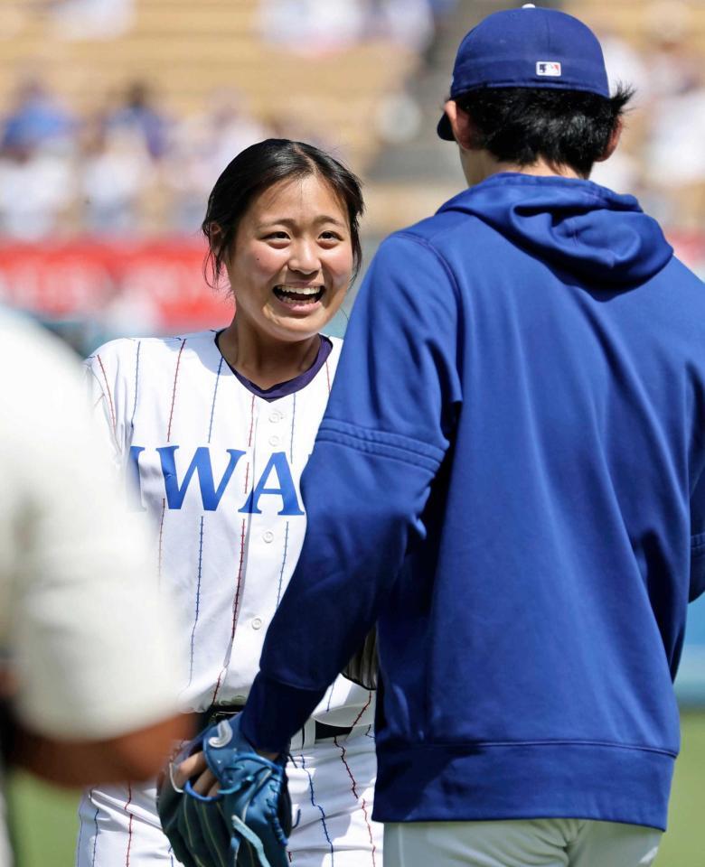 　始球式を務め、捕手役の佐々木朗（右）と握手を交わす花巻東高の寺本悠里さん（共同）