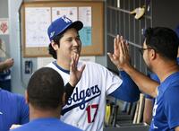 　ブレーブスに勝利し笑顔でタッチを交わすドジャース・大谷＝ロサンゼルス（共同）