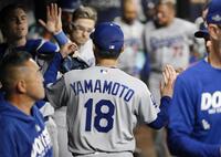 　ブレーブス戦で７回を投げ終えベンチで迎えられる山本＝アトランタ（共同）