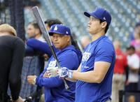 　試合前、打撃練習を行う大谷。左はロバーツ監督（共同）