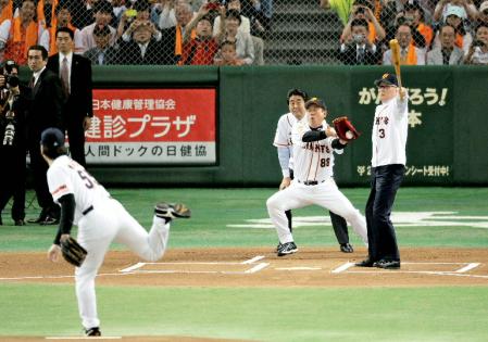 　国民栄誉賞授与式後の始球式で、松井秀喜氏の投球にバットを振る長嶋茂雄氏。捕手は巨人の原監督、球審は安倍首相＝５日午後、東京ドーム