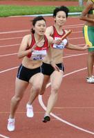 　女子４００メートルリレーでアンカー・佐野（左）にバトンを渡す福島（共同）