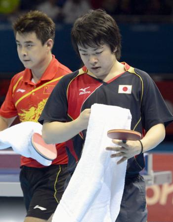 　男子シングルス準々決勝で中国の王皓（左）に敗れた岸川聖也（共同）