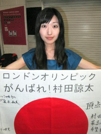 　寄せ書きされた日の丸を手に、ロンドンで夫を応援する村田の妻・佳子さん