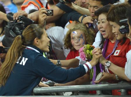 　母・満壽子さんにメダルをかける沢（左）