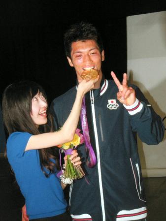 　佳子夫人（左）に金メダルをかじらせてもらい、Ｖサインの村田諒太