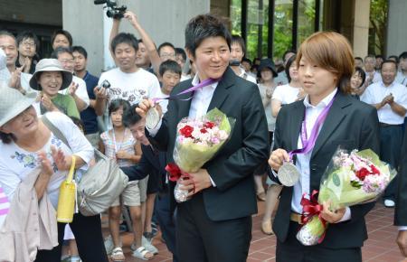 　ロンドン五輪の銀メダルを手に、岡山県庁で祝福を受ける「なでしこジャパン」の（右から）主将宮間あや、福元美穂の両選手＝１３日午後