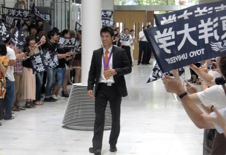 　学生や職員に迎えられ、金メダルを胸にさっそうと初出勤する村田諒太