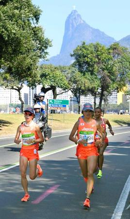 　力走する田中智美（左）と福士加代子。後方はキリスト像が立つコルコバードの丘（共同）