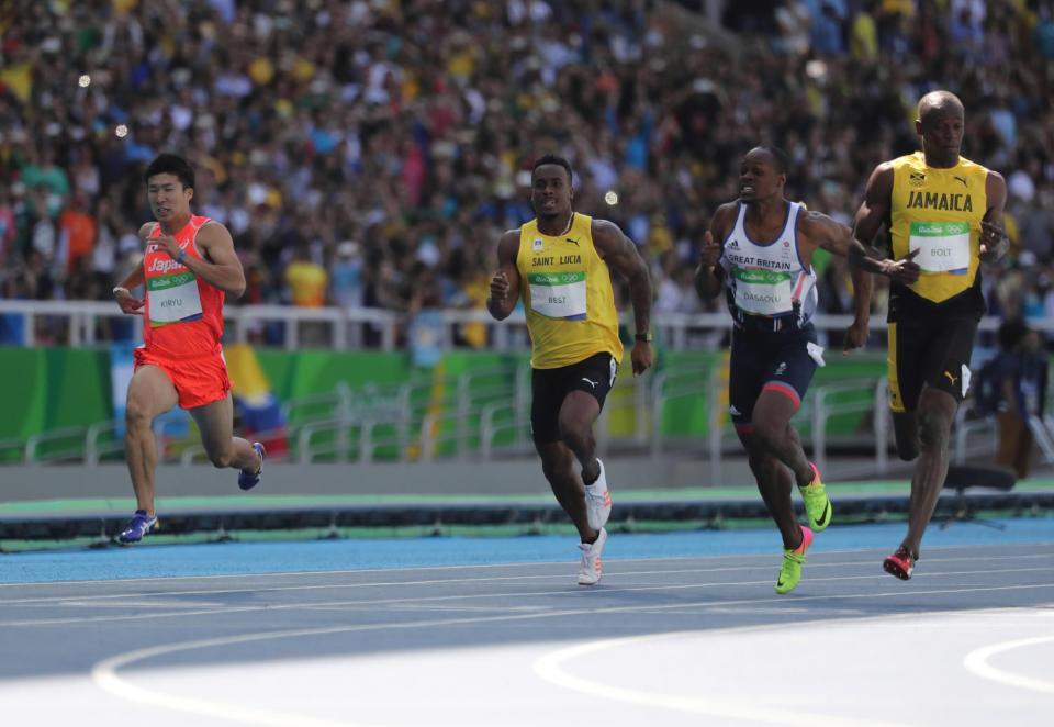 　男子１００ｍ予選で走る桐生祥秀（左）。右はウサイン・ボルト