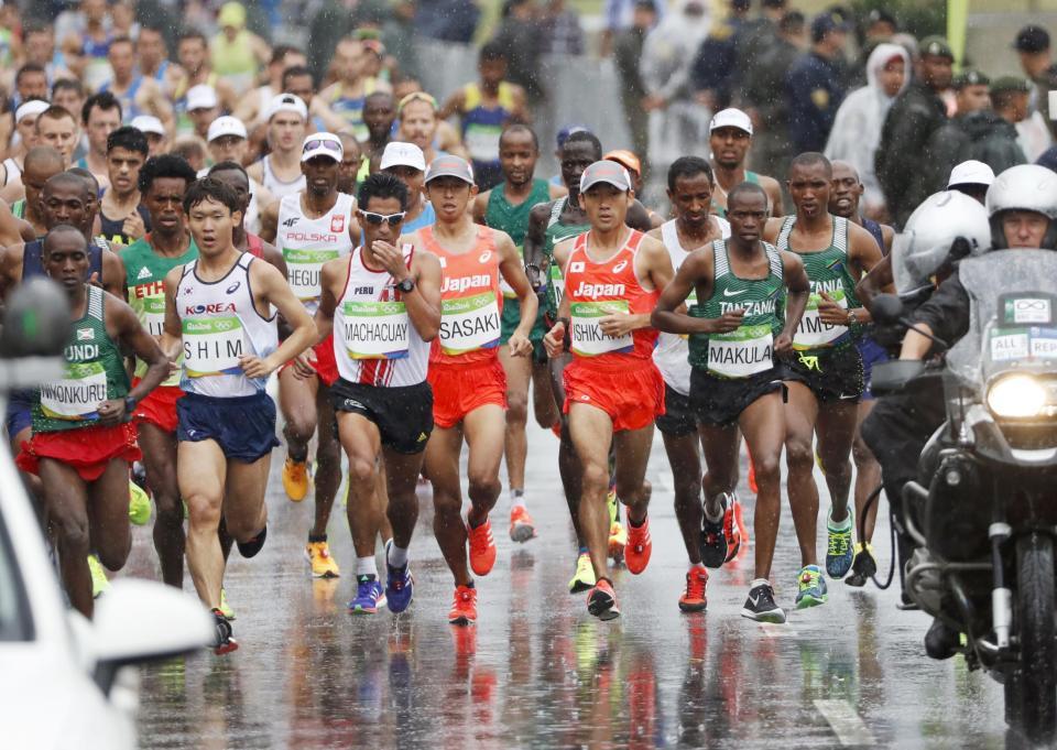 　男子マラソン　雨の中、スタートする佐々木悟（中央左）、石川末広（同右）ら＝リオデジャネイロ（共同）