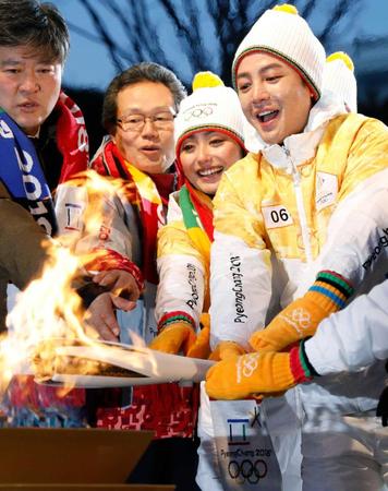 　平昌冬季五輪の聖火リレーに参加し、聖火台に火をともす安藤美姫さん（左から３人目）、チャン・グンソクさん（同４人目）ら