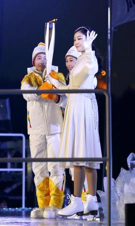 　平昌冬季五輪の開会式で元フィギュアスケート女子のキム・ヨナさん（右手前）に手渡された聖火＝９日夜（共同）