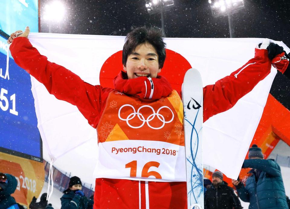 　平昌五輪のフリースタイルスキー男子モーグルで銅メダルを獲得し、日の丸を掲げる原大智（共同）