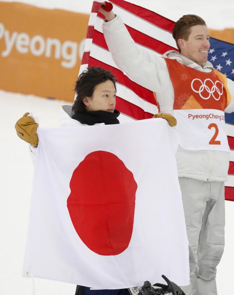 　スノーボード男子ハーフパイプのセレモニーで日の丸を広げる銀メダルの平野歩夢。右は金メダルを獲得した米国のショーン・ホワイト＝平昌（共同）