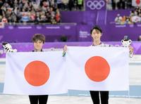 日の丸を手に笑顔を見せる宇野昌磨（左）と羽生結弦＝江陵（撮影・高部洋祐）