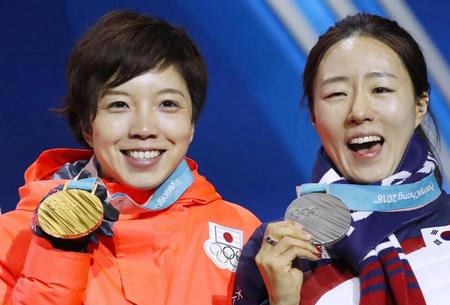 　獲得した金メダルを手に笑顔の小平奈緒（左）と銀メダルの韓国・李相花（共同）