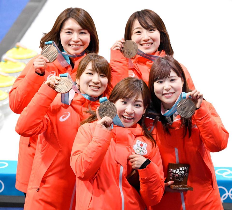 　銅メダルを掲げ笑顔のカーリング女子日本代表。（左上から時計回りに）本橋、藤沢、吉田夕、吉田知、鈴木（共同）