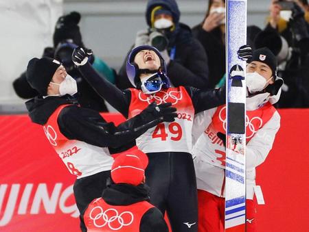 　男子個人ノーマルヒルで日本選手団第１号となる金メダルを獲得し、喜ぶ小林陵侑（中央）。左は兄・潤志郎