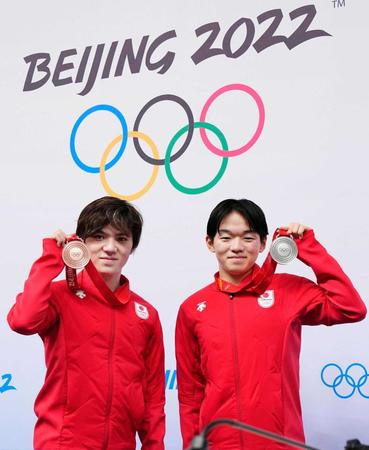 　一夜明けの記者会見でメダルを掲げる、フィギュアスケート男子で銀の鍵山優真（右）と銅の宇野昌磨（共同）