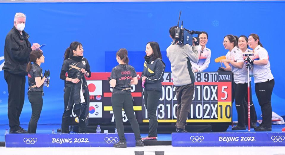 　敗れて肩を落とすカーリング女子日本代表。右端は喜ぶ韓国＝１４日