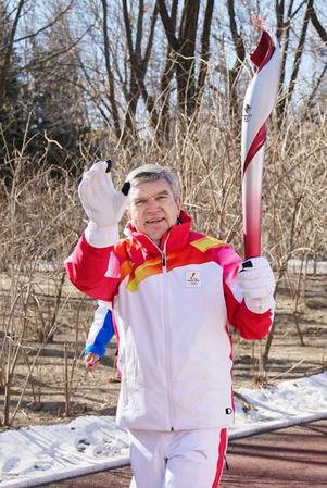 　４日に行われた聖火リレーで、トーチを掲げて走るＩＯＣのバッハ会長（共同）