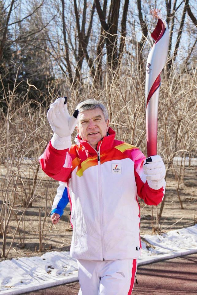 　４日に行われた聖火リレーで、トーチを掲げて走るＩＯＣのバッハ会長（共同）