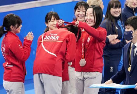 　カーリング女子で銀メダルを獲得し、石崎（手前左）にメダルを掛ける藤沢＝２０日、北京（共同）