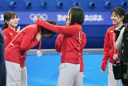 　カーリング女子で銀メダルを獲得し、石崎（左手前）にメダルを掛ける藤沢（中央）。左奥は吉田夕、右は吉田知＝２０日、北京（共同）