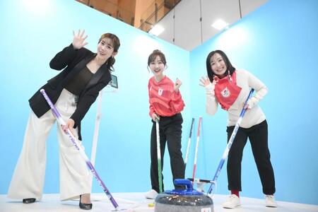 カーリングブース体験の撮影でポーズを決める（左から）中川安奈、本田望結、藤沢五月（撮影・開出牧）