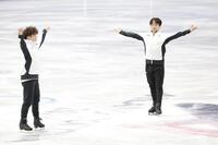 練習後、両手を広げあいさつしる鍵山優真（右）と佐藤駿＝ミラノアイススケートアリーナ（撮影・吉澤敬太