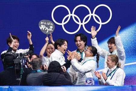 団体男子ＳＰの得点を確認し、坂本花織（前列右から２人目）と手を合わせて喜ぶ鍵山優真（共同）