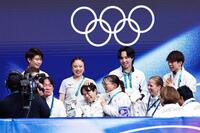 団体男子ＳＰの演技を終え、キスアンドクライで坂本花織（中央右）に頭をなでられる鍵山優真（共同）