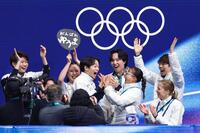 団体男子ＳＰの得点を確認し、坂本花織（前列右から２人目）と手を合わせて喜ぶ鍵山優真（共同）