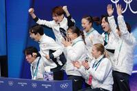 団体男子ＳＰの演技を終え、得点を確認し喜ぶ鍵山優真（左から２人目）＝共同