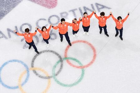 銀メダルを獲得し、表彰式に臨む日本チーム。左からアイスダンスの森田真沙也、吉田唄菜、ペアの木原龍一、三浦璃来、女子の坂本花織、男子の佐藤駿、鍵山優真＝ミラノ（共同）