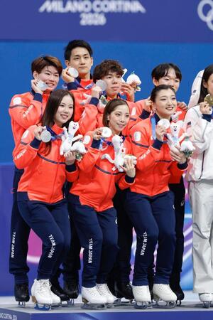 団体で銀メダルを獲得し記念撮影する（前列左から）吉田唄菜、三浦璃来、坂本花織、（中列左から）森田真沙也、佐藤駿、鍵山優真。奥は木原龍一＝ミラノ（共同）