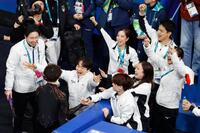 団体男子フリーの演技を終えた佐藤駿（左下）を出迎える鍵山（右隣）ら＝ミラノ（共同）