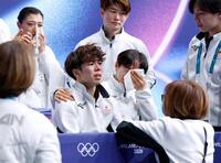 団体男子フリーの得点を確認し、涙を流す佐藤駿（中央左）の肩を抱く鍵山優真＝ミラノ（共同）