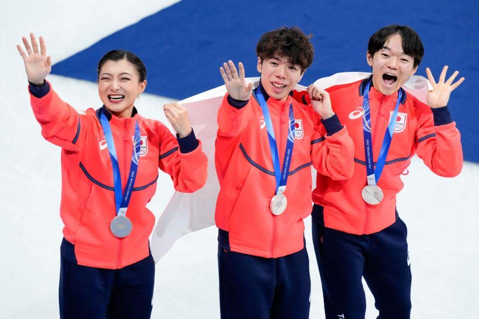 団体で銀メダルを獲得し、歓声に応える（左から）坂本花織、佐藤駿、鍵山優真＝ミラノ（共同）