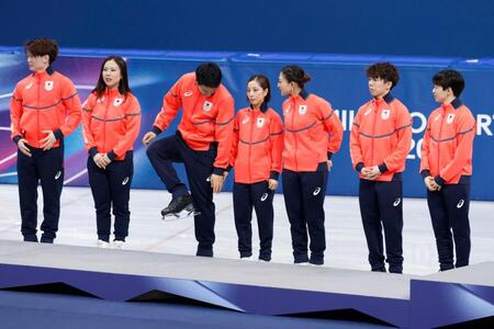 フィギュアスケート団体の表彰台の前で靴のブレードを気にする木原龍一（左から３人目）＝共同