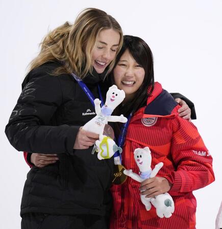 　女子ビッグエアで金メダルを獲得し、銀メダルのゾイ・サドフスキシノット（左）と健闘をたたえ合う村瀬心椛＝リビーニョ（共同）