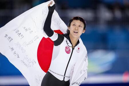 　女子１０００メートルで銅メダルを獲得し、日の丸を掲げる高木美帆＝ミラノ（共同）