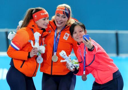 女子１０００メートルで２位のフェムケ・コク（左）、優勝したユタ・レールダム（中）と自撮りする３位の高木美帆