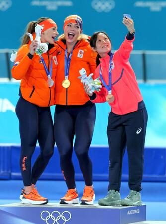 女子１０００メートルで２位のフェムケ・コク（左）、優勝したユタ・レールダム（中）と自撮りする３位の高木美帆